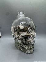 Full view of glass skull jar filled with coins