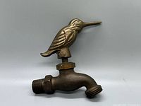 Profile view of brass faucet showing hummingbird handle and threaded connections