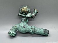 Angled view showing full faucet and snail handle with verdigris patina