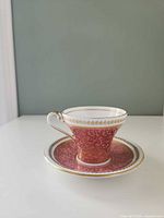 Teacup on saucer, front view showing pattern and gold trim