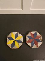 Front view of both octagonal barn quilt wall hangers showing painted star patterns