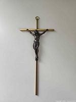 Front view of slim brass crucifix with dark corpus