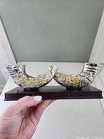 Front view of shofar-form candle holder showing Hebrew script and overall design