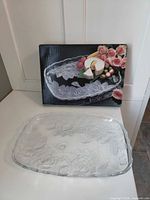 Dish on surface with box standing behind showing product image