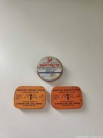 Front view of all three tins showing labels and colours