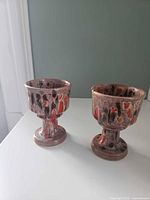 Two ceramic goblets side by side showing drip-glaze pattern and pedestal form