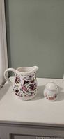 Front view of floral pitcher and sugar dish