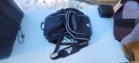 Front view of black Adidas duffel bag showing logo and shape