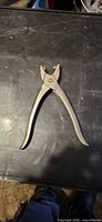Full view of leather hole punch plier on tabletop