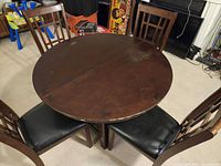 Round wooden table with four chairs around it