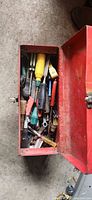 Top view of open red toolbox packed with assorted hand tools