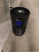 Air purifier plugged in, blue UV-C ring lit