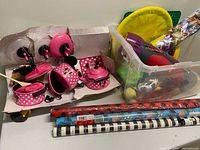 Overall lot showing Minnie Mouse cookware, toy bin, gift wrap rolls