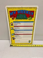 Full view of chore chart board with tape measure for scale