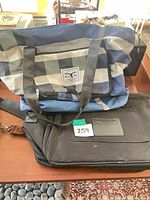 Plaid tote and black laptop bag stacked