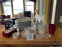 Full assortment on countertop including plates, creamer, utensil holder, votives, mug, disposable cups, napkin rings, ramekin and V-Gauge pourer