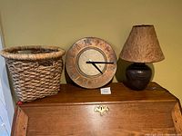 Basket, wall clock and lamp displayed together