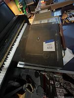 Turntable closed under dust cover on piano top