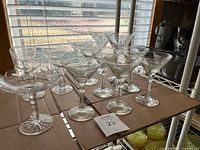 Full group of clear stemmed cocktail glasses on shelf