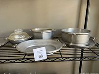 Five Guardian Service hammered aluminum cookware pieces displayed on wire shelf