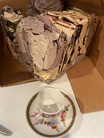 Teacup, saucer and box with wrapped matching pieces