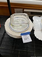 Stack of plates with glass square dish and lid on top