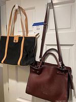 Front view of both handbags hanging to show size and style