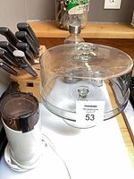 Cake stand with dome and partial view of grinder and utensils
