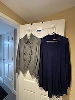 Both sweaters hanging on door