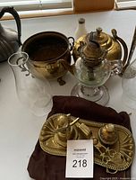 Group shot showing brass bowl, oil lamp, kettle, chimneys and desk set