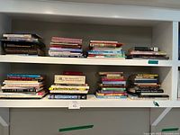 Wide view of both shelves showing numerous stacked and shelved books