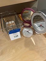 All items grouped: wire basket with soap dish, purple mirror, clear alarm clock, white ring vanity mirror