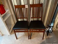 front view of both folding chairs showing slatted backs and seat cushions