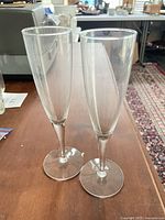 Two clear glass champagne flutes standing upright