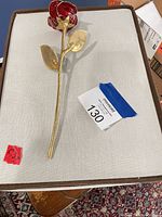 Gold-tone metal rose with red enamel petals on box lid