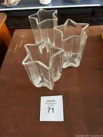 Three clear star-shaped glass vases on table