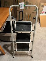 Front view of white three-step folding ladder