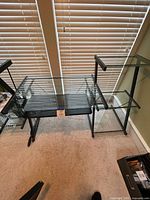 Full view of desk showing glass top, metal frame, side shelving