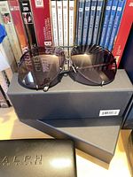 Aviator sunglasses on storage box beside case