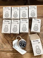 Nine boxed Master Lock padlocks and one opened to show dial