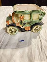 Left side view of ceramic car planter showing glazing and wheel detail