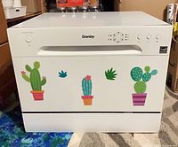 Front view of white Danby countertop dishwasher with decals