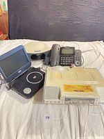 All four electronic items grouped on bed