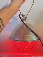 Heat lamp illuminated showing red glow and hanging loop