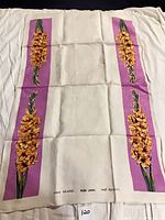 Front view of linen tea towel showing gladiolus design on purple panels