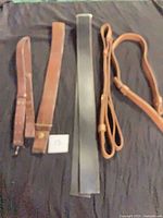All five leather straps laid out on dark surface