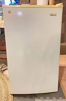Front view of white Magic Chef compact fridge