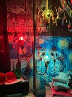 Full view of tension pole lamp with two lit fixtures showing colored bulbs and hanging prisms