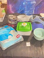 Group shot showing all items: Catit fountain, gravity waterer, stainless and ceramic bowls, training pads, harness