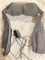 Full view of Quantum neck & shoulder massager with attached power adapter